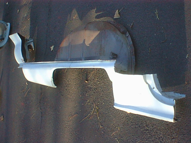 White inner fender panel pieces with wheel arch on pavement