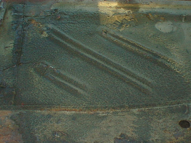Close-up of rusty ribbed floor pan sheet metal