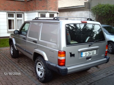 2000 Jeep Cherokee - A silver 2000 Jeep Cherokee van is parked on a brick driveway.