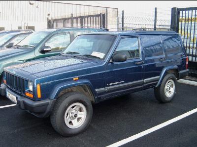 2000 Jeep Cherokee - A blue 2000 Jeep Cherokee Sport is seen parked in a lot with other vehicles.