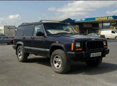 2000 Jeep Cherokee - This dark blue Jeep Cherokee, likely a 1997 model based on its body style, is seen parked at a gas station with a roof rack.