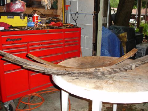 1989 Ford Bronco - Leaf springs are shown resting on a table, with a red Snap-On toolbox and various tools in the background.