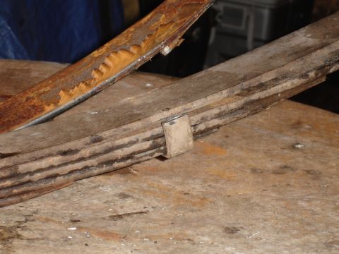 1989 Ford Bronco - Close-up of heavily rusted leaf springs, likely from an older vehicle.