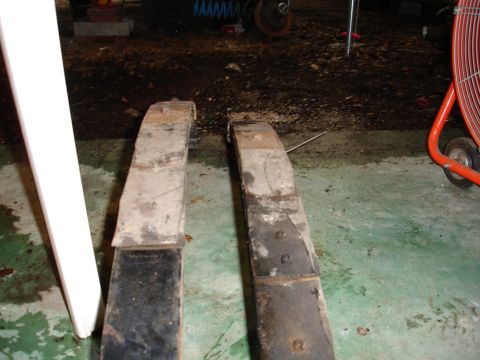 1989 Ford Bronco - Two leaf springs are shown, likely removed from a vehicle for repair or replacement.