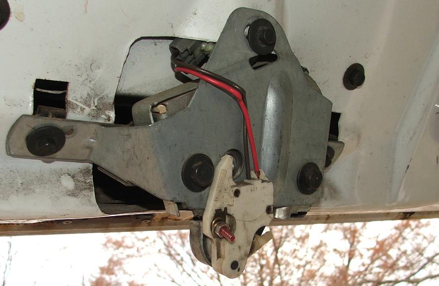Close-up of a car's trunk latch mechanism with red and black wires