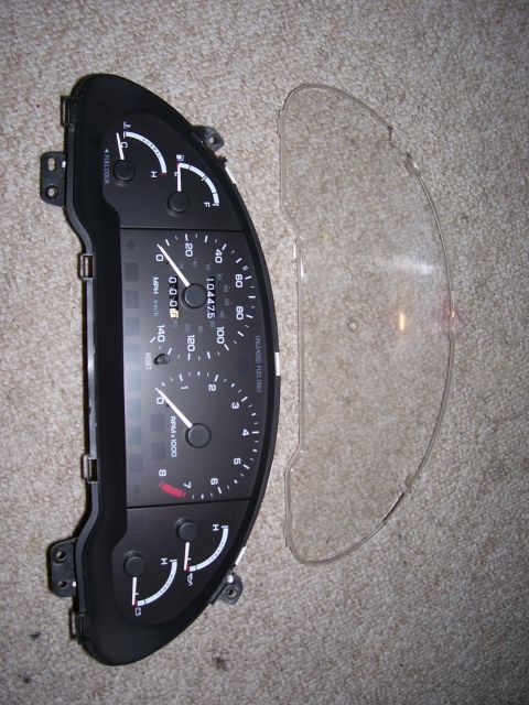 1993 Mazda MX-6 - Instrument cluster and its clear cover, likely for a car part replacement.