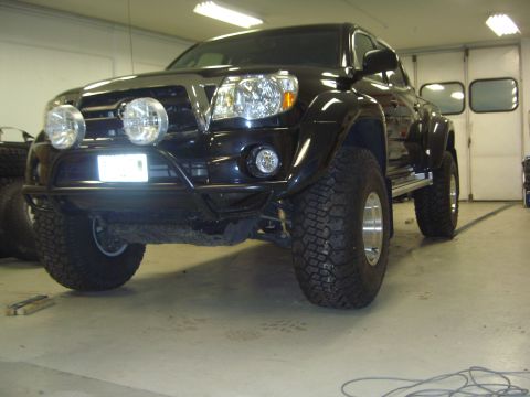 1996 Ford Bronco - This modified Toyota Tacoma pickup truck is shown from the front in a garage setting.