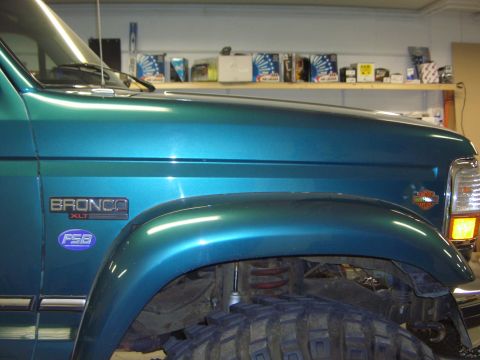 1996 Ford Bronco - Teal 1996 Ford Bronco XLT shows its fender and hood with a large off-road tire below.