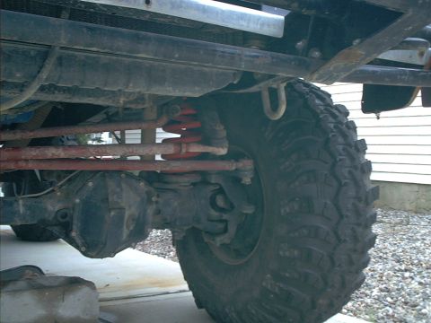 1978 Ford Bronco - The underside of a vehicle shows its heavy-duty suspension components and large off-road tire.