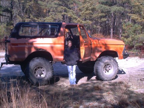 1978 Ford Bronco - This lifted Ford Bronco is parked outdoors with trees in the background.