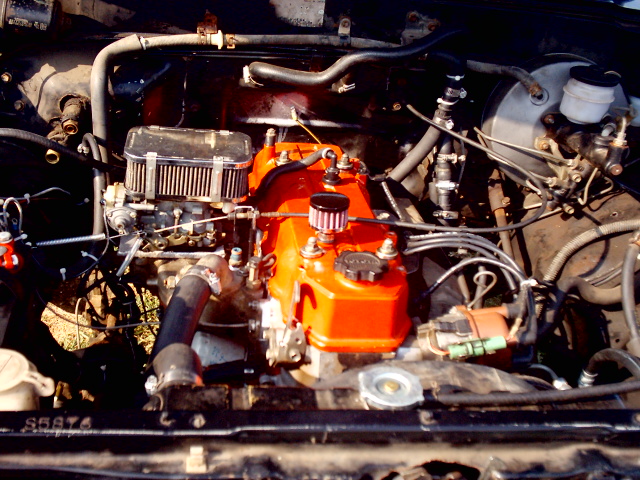 engine bay with orange valve cover and chrome air filter