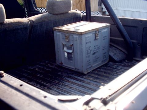 1988 Toyota 4Runner - Metal ammo can with text markings sits on the bed floor behind rear seats of an SUV.