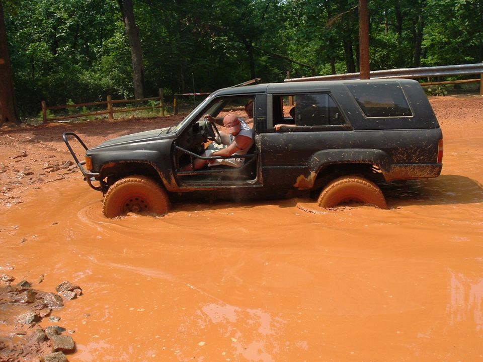 Black 1988 Toyota 4Runner driving through mud pit