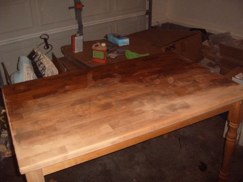 1988 Ford Bronco - A dining table is in the process of being refinished in a garage setting, with various supplies visible.