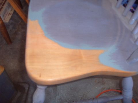 1988 Ford Bronco - A chair seat is partially painted blue and gray, with some of the original wood grain visible.
