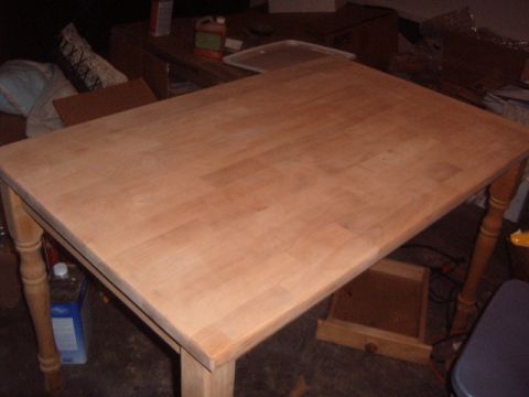 1988 Ford Bronco - A wooden dining table with turned legs sits in a workshop, ready for refinishing.