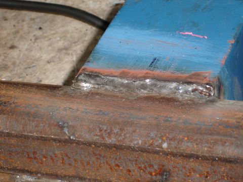 1989 Ford Bronco - Close-up of a welded metal joint, showing both painted blue and rusted components.