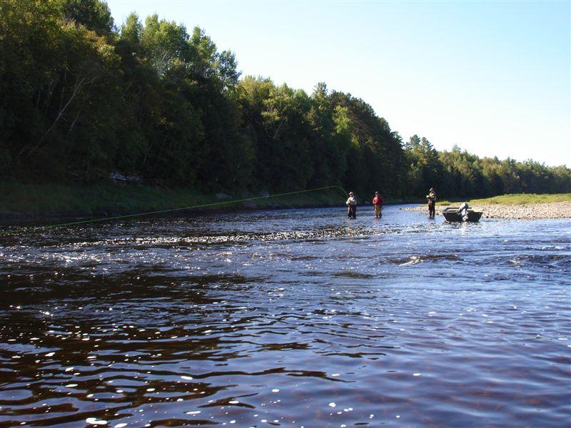People fishing in a river with a boat