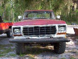 1974 Ford F-100 - Frontal view of a red 1975 Ford F-Series truck with a prominent grille and chrome bumper.