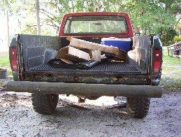 1974 Ford F-100 - Rear view of a red 1973 Ford F-100 pickup truck with a wood-filled bed and a cooler.