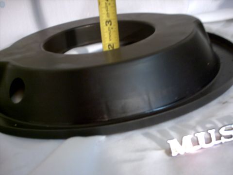 1965 Ford Mustang - Air cleaner housing with a measuring tape and a partial 'MUS' emblem.