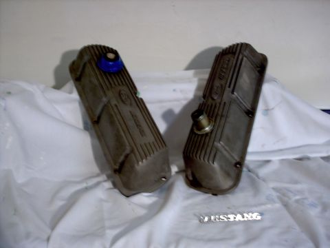 1965 Ford Mustang - Two aluminum valve covers, one with a blue oil cap, are shown on a white cloth surface.