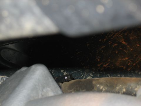 1995 Ford Bronco - Close-up of a bolt on the underside of a vehicle, likely part of the suspension system.