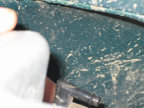 1995 Ford Bronco - A close-up shows a black plastic connector on a teal surface with white speckles and dirt.