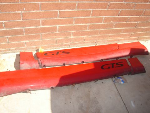 1997 Ford Probe - These red side skirts, marked with 'GTS', appear to be aftermarket parts for a vehicle.