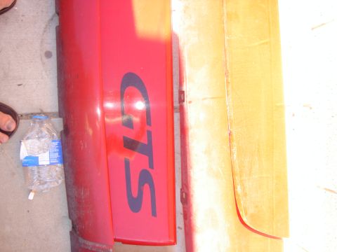 1997 Ford Probe - Close-up of a red car bumper with GTS lettering, alongside another panel.