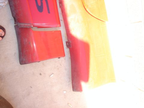 1997 Ford Probe - Several red and yellow car body panels are visible, some with markings. The image includes a watermark for Supermotors.net.