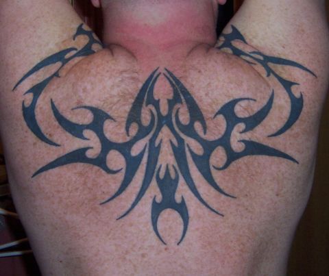 1979 Ford F-150 - A large tribal tattoo covers the upper back of a person. The Supermotors.net logo is in the lower right corner.