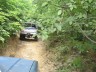 1989 GMC Jimmy - Two off-road vehicles navigate a wooded trail.