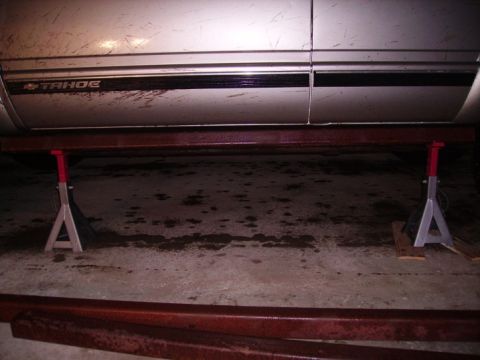 2000 Chevrolet Tahoe - The side of a silver Chevrolet Tahoe is shown supported by jack stands.