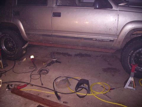 2000 Chevrolet Tahoe - A 2000 Chevrolet Tahoe is shown with various tools and equipment scattered around it on the garage floor.