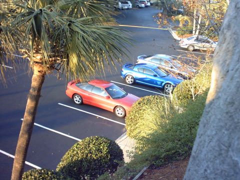 1997 Ford Probe - A red 1997 Ford Probe is parked in a lot next to other vehicles.