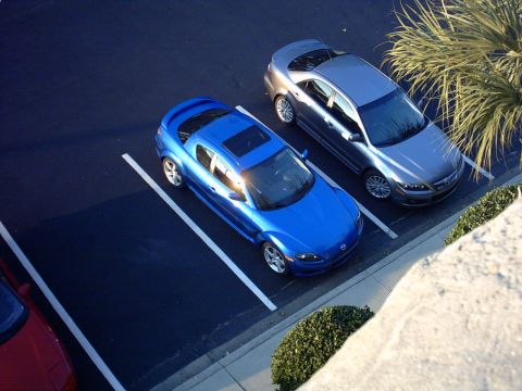 1997 Ford Probe - Two cars parked in a lot, a blue Mazda RX-8 and a silver Mazda 6.