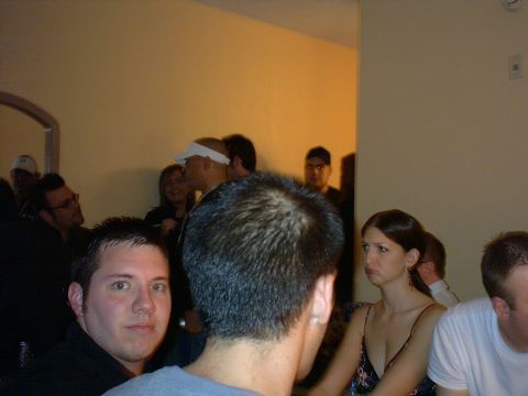 1997 Ford Probe - A group of people are seen indoors, with some individuals looking towards the camera while others interact.