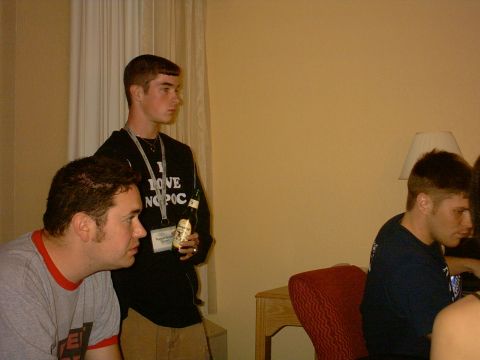 1997 Ford Probe - Three men are gathered in a room, with one holding a bottle and wearing a shirt with text.