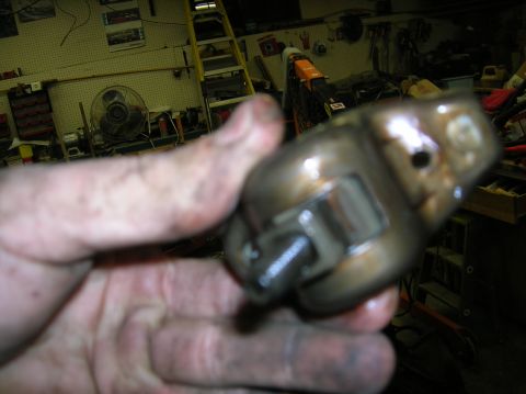 1994 Ford Bronco - A close-up of a metal engine component is held by a hand, with a Supermotors logo in the lower right corner.