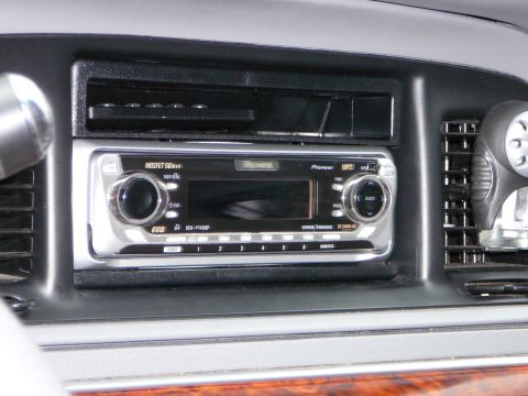 1997 Mercury Grand Marquis - Close-up of a car's dashboard showing an aftermarket stereo system and air vents.