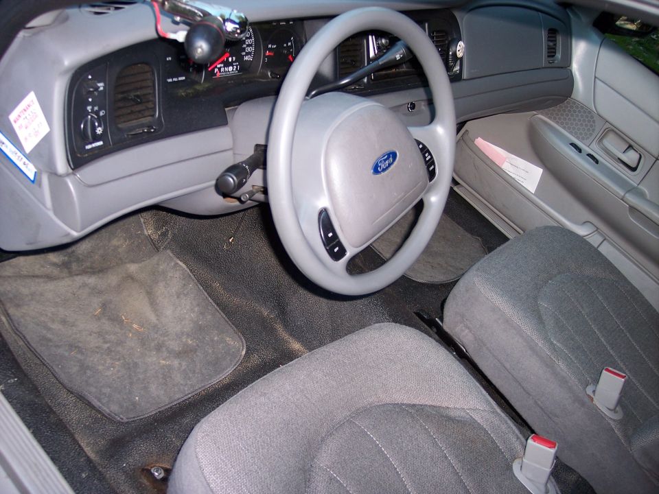 Gray cloth interior of a Ford sedan with Ford steering wheel