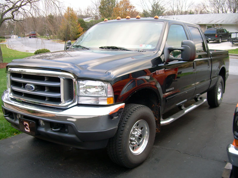 Black Ford F-250 Super Duty crew cab 4x4 pickup parked in a driveway