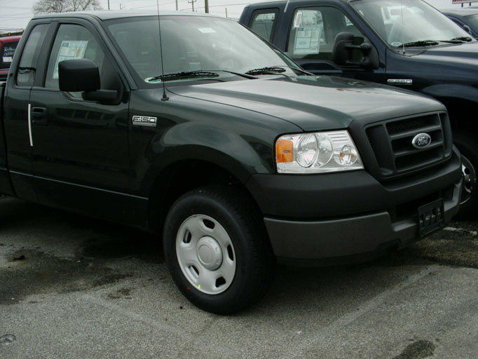 Dark green Ford F-150 regular cab pickup on a dealer lot