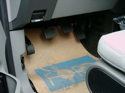 1997 Ford F-150 - The interior of a 2005 Ford F-150 XL shows the brake, clutch, and accelerator pedals with a Ford logo floor mat.