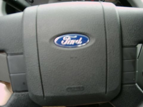 1997 Ford F-150 - Close-up of a Ford steering wheel, showing the blue oval emblem and part of the dashboard.