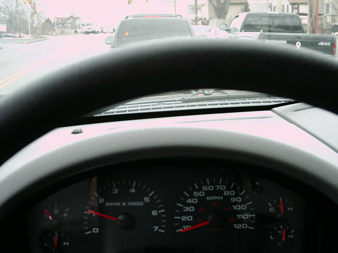 Dashboard view of a 2005 Ford F-150, showing speedometer and RPM gauges. Traffic ahead