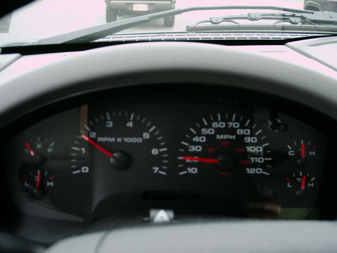 Dashboard gauges with red needle on tachometer at 2000 RPM and speedometer at 30 MPH. Water and fuel gauges visible