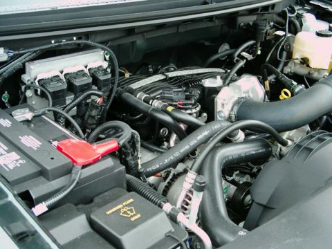1997 Ford F-150 - Close-up view of a vehicle's engine bay, showing the battery, hoses, and various engine components.
