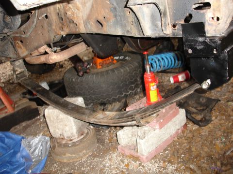 1989 Ford Bronco - Vehicle undercarriage with suspension components and a spare tire visible.